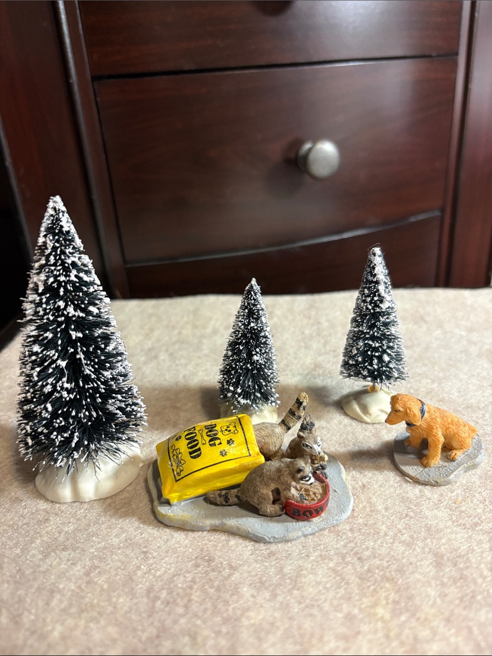 Dog & Bag of Dogfood being eaten by Raccoons with 3 trees in Background